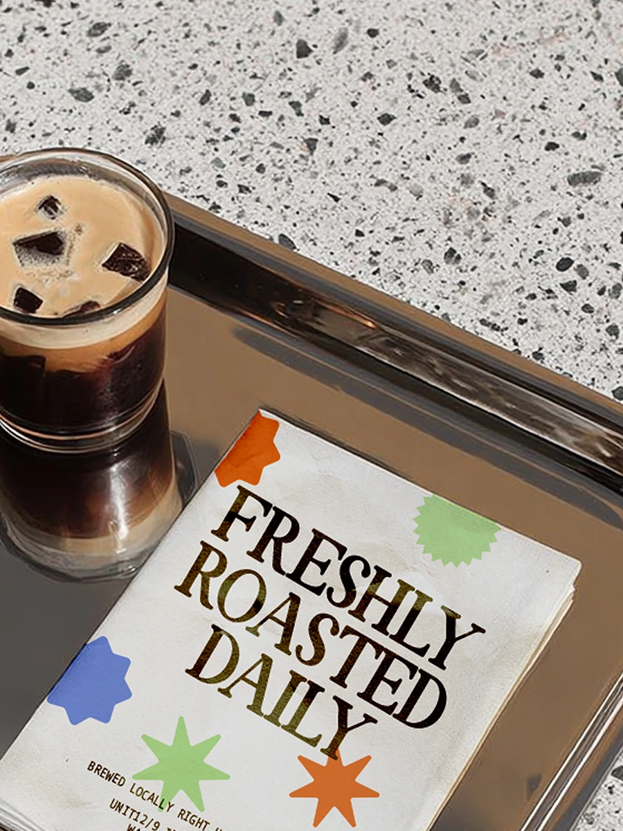 Freshly Roasted Daily sign alongside roasted coffee beans in a Brew Coffee café environment