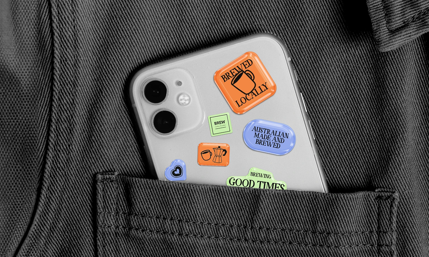 Close-up of colourful illustrated stickers on a denim surface, including a 'Soo Fresh' branded design and other round illustrated patches