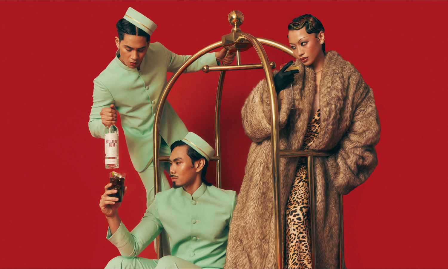 Hotel Lobby Rum campaign image featuring two models in retro 1970s-style outfits against a vibrant red background