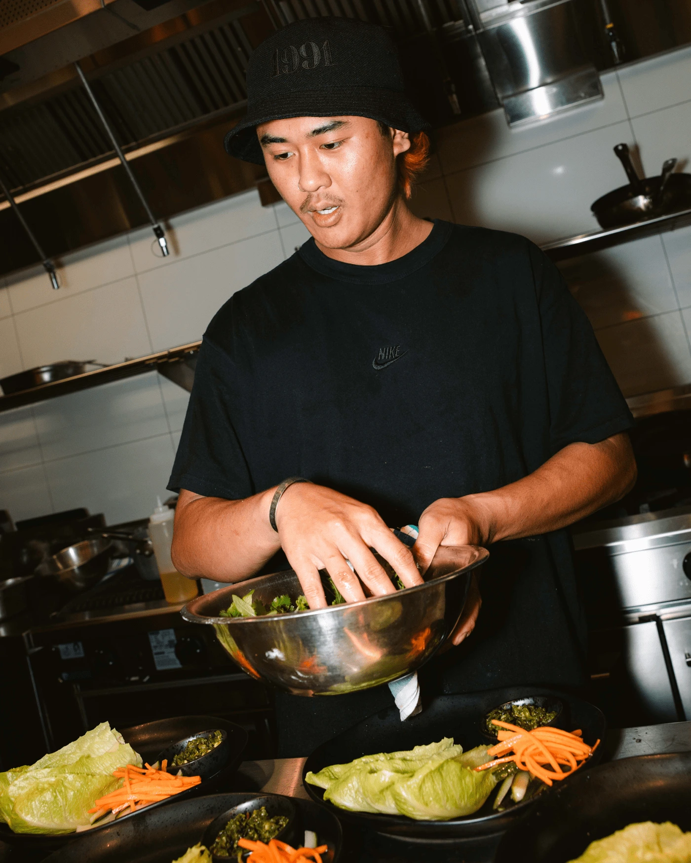 A chef in a black hat cooking in a dimly lit restaurant kitchen — Moon & Mary restaurant kitchen photography