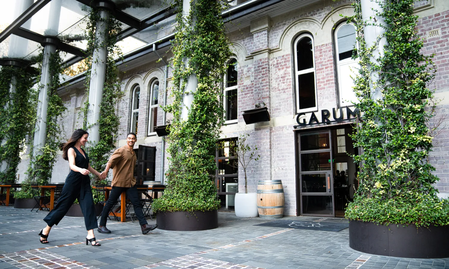 Garum restaurant exterior covered in lush ivy with people walking past on the street