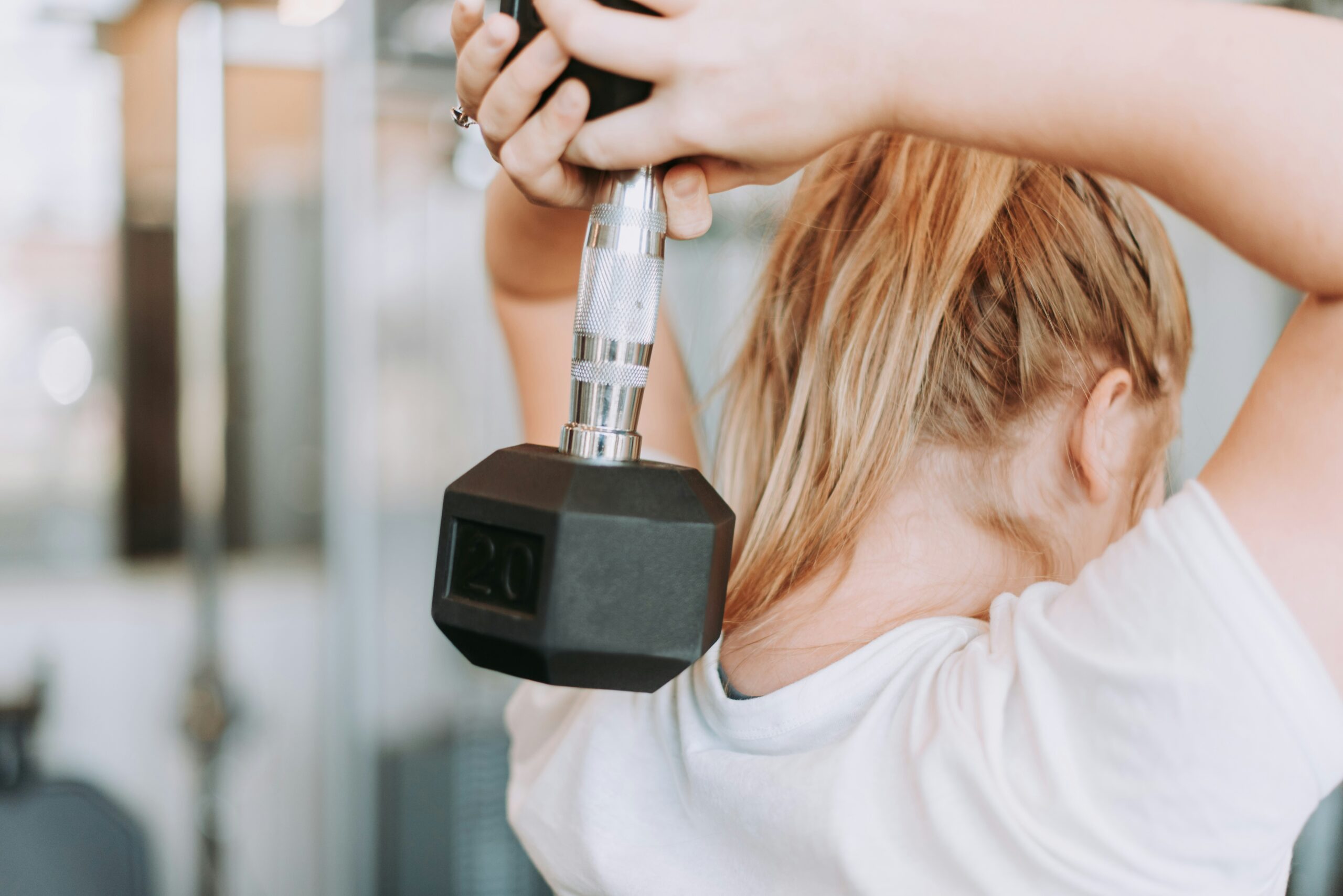 Woman lifting a dumbbell at a gym in athletic wear — fitness stock photograph