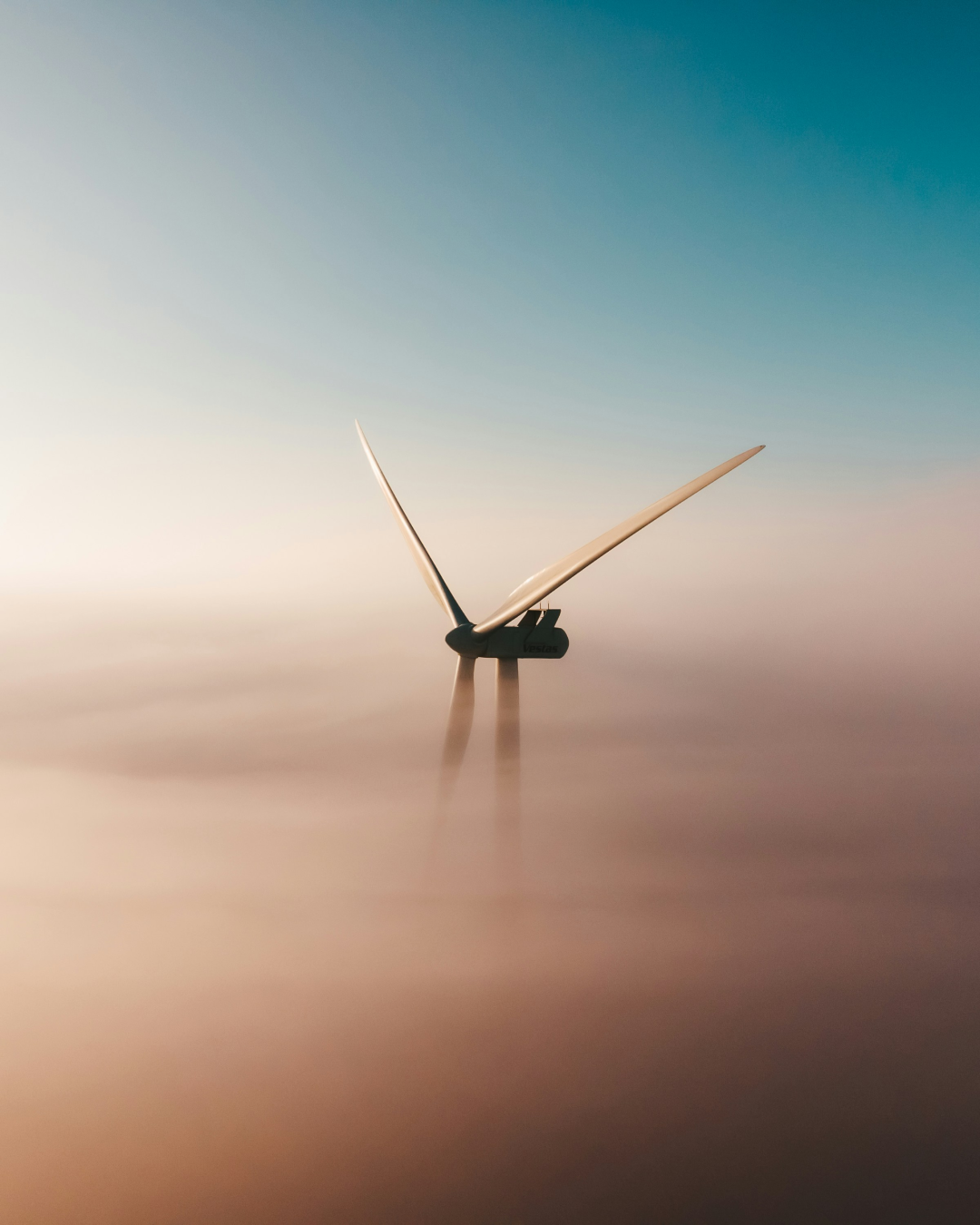 Offshore wind turbines in misty atmospheric conditions over a dark sea