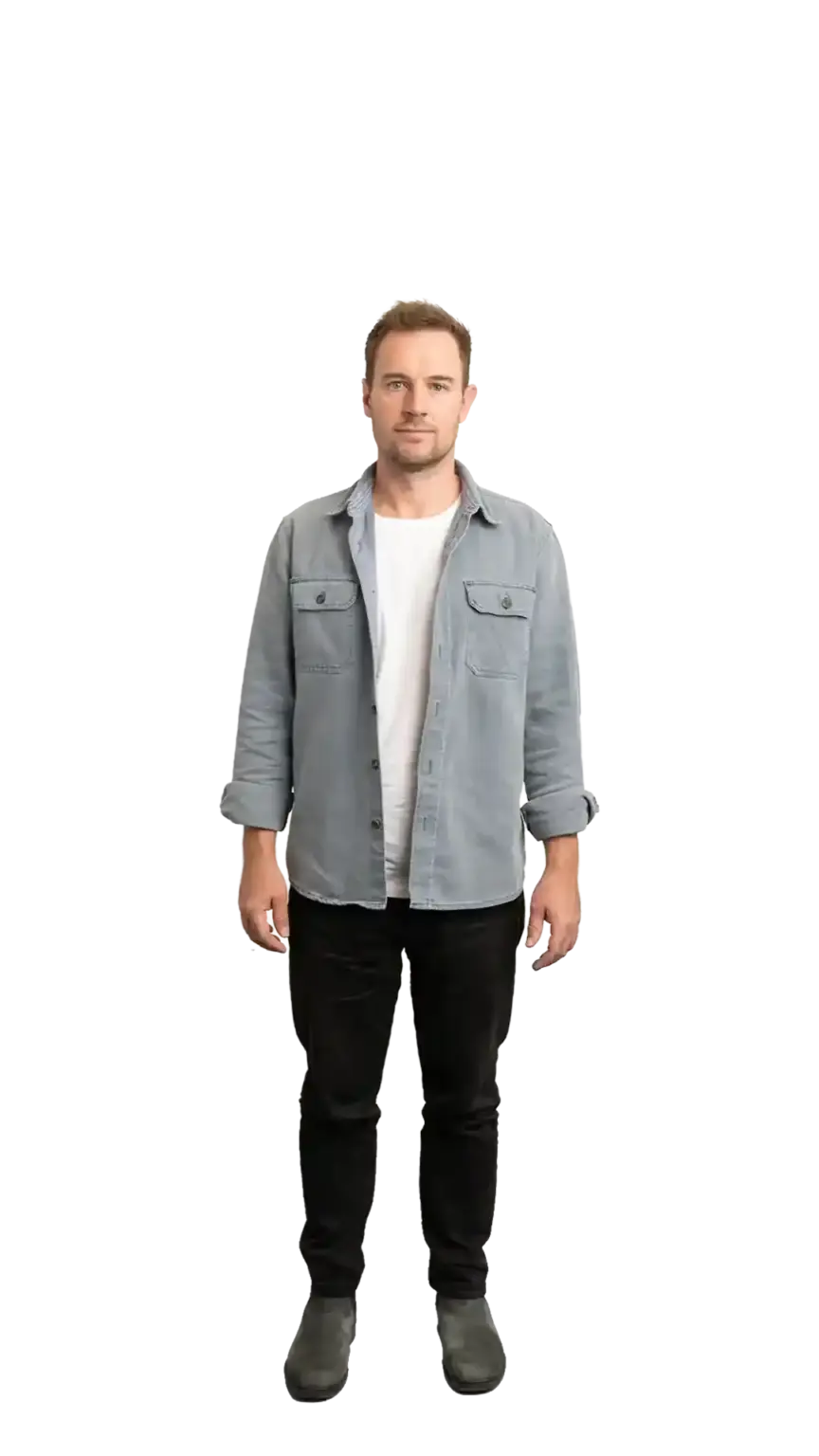 Ian Hollinshead, Client Services Manager at The Start, standing in a full-body portrait — light grey shirt, light trousers, white sneakers, smiling