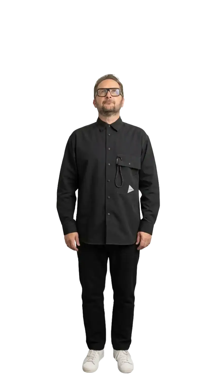 Neil Mason, Managing Director at The Start, full-body portrait — dark outfit, white sneakers, looking upward