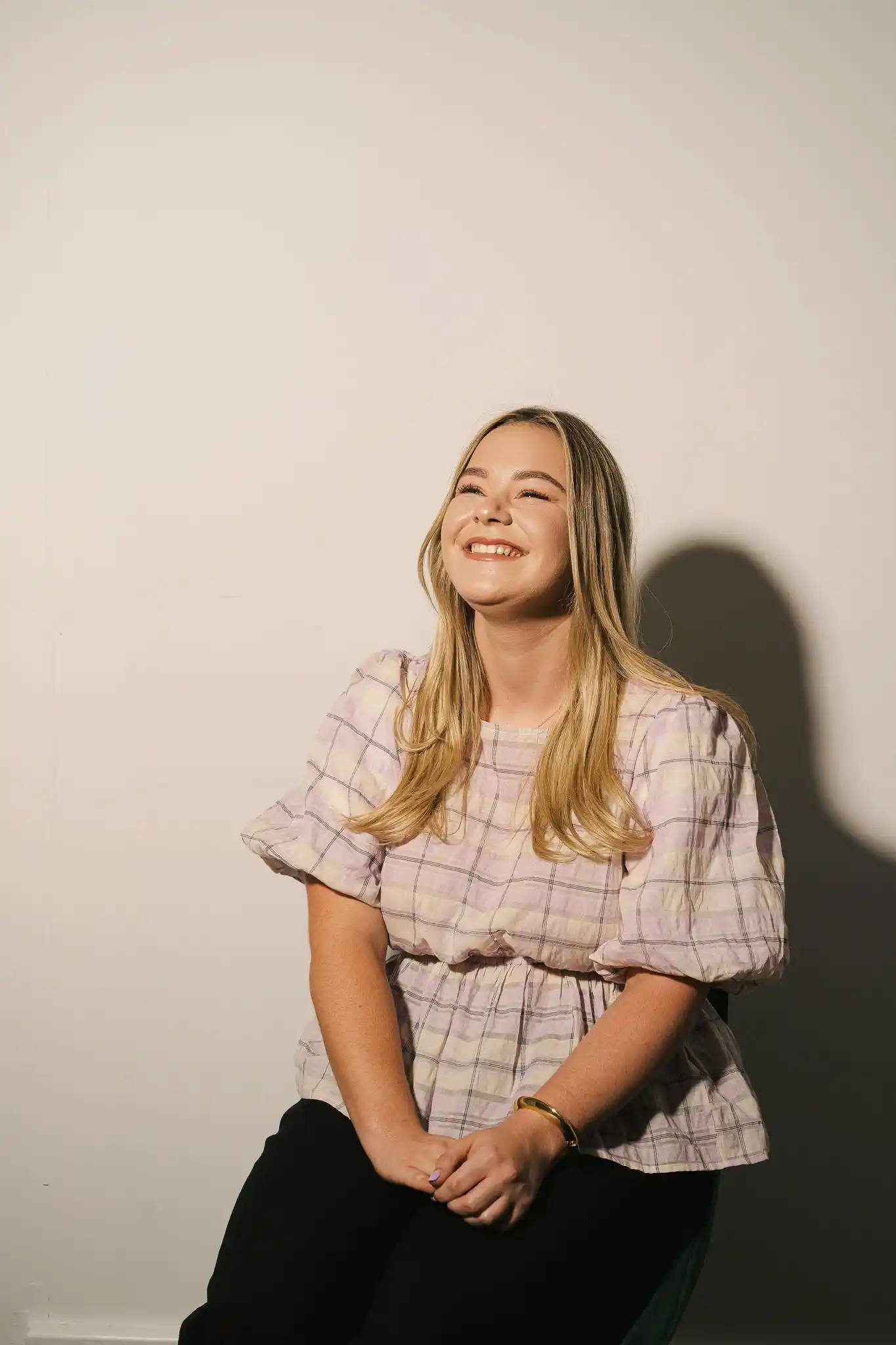 The Start team member seated in a relaxed pose, wearing a light-coloured top, smiling — portrait photo, January 2026